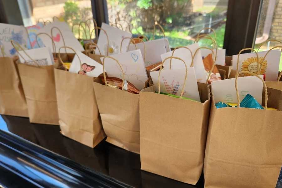 A row of brown paper bags filled with handmade cards, ready to be mailed